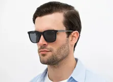 Lentes de sol INVU con montura cuadrada negra de acetato y lentes polarizadas grises.