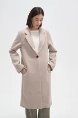 Tapado de corte recto con solapas clásicas y cierre frontal de un botón. Presenta mangas largas y bolsillos laterales integrados.