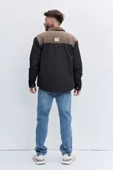 Cazadora acolchada de corte recto con diseño bicolor, presentando un panel superior en color marrón y cuerpo en color negro. Cuenta con cuello clásico, cierre frontal de botones y bolsillos delanteros con solapa.