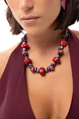 Collar corto compuesto por una combinación de piedras reconstituidas, piedras naturales y cristales checos en tonos rojos, azules y turquesas. Cuenta con un cierre de cadena de acero quirúrgico ajustable.