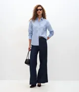 Camisa de tricolina de algodón con estampa de rayas celestes y blancas, cuello solapa, abotonado frontal y mangas largas. Marca Cortelle.
