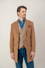 Chaquetón de lana color beige, con solapas clásicas, cierre frontal de botones y bolsillo en el pecho con pañuelo decorativo.