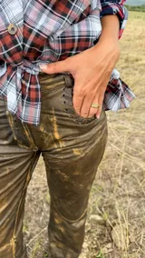 Pantalón de cuero estilo western con efecto desgastado y costuras decorativas en los bolsillos delanteros. Presenta un corte recto y holgado con costuras horizontales a la altura de la rodilla.