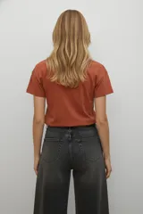 Remera de algodón negra de manga corta con cuello redondo. Presenta un estampado frontal abstracto compuesto por líneas verticales en tonos azules y detalles de lentejuelas plateadas, acompañado por el texto 'ABSTRACT MOTION'.