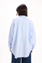 Camisa de corte oversize color marrón, con cuello clásico, cierre frontal de botones y bolsillo en el pecho.