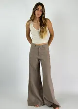 Pantalón de lino color beige, de tiro alto y corte wide leg, con costuras frontales y bolsillos laterales.