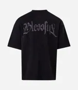 Remera oversize de tejido tipo gamuza sintética negra, con cuello redondo, manga corta y bordado de cruz gótica en el pecho.