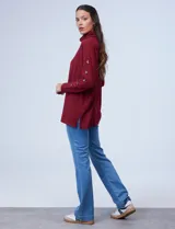 Polera negra de tejido soft con cuello alto y mangas largas con aplique de botones.