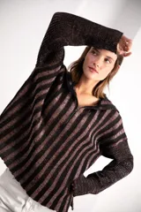 Buzo de punto con diseño de rayas verticales en negro y marrón con hilos de lurex brillantes. Presenta un corte oversized, cuello con medio cierre frontal y mangas largas con logo tejido en el puño.