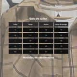 Sobrecamisa de franela a cuadros blancos, negros y grises, de manga larga, con cuello camisero, cierre abotonado y bolsillo en el pecho.