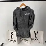 Canguro gris con efecto lavado, corte oversize y estampa en el frente con la frase "Growing Like a Flower" y un diseño de una flor en verde y blanco.