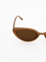 Lentes de sol con armazón de estilo cat-eye en color caramelo y cristales oscuros.