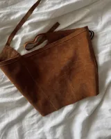 Culerito de descarne vacuno color negro, con diseño envolvente y flecos laterales. Cuenta con tiras para atar en la cintura y etiqueta de la marca Lucy in the Sky.