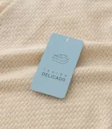 Camisa masculina de manga corta, color crema, con cuello bowling y calce boxy. El tejido presenta un efecto punto texturizado.