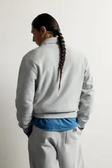Sudadera gris de corte relaxed fit con cuello alto y cierre frontal de cremallera corta, confeccionada en algodón con interior de rizo afelpado. Presenta mangas largas, puños y bajo de rib, y un parche bordado con el logotipo de Fruit of the Loom en el pecho. Colección especial Fruit of the Loom x Zara.