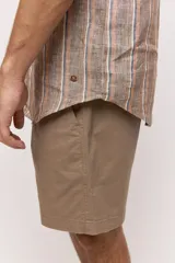 Camisa de manga corta con diseño a rayas verticales en tonos tostado, blanco y azul. Cuenta con cuello clásico y cierre frontal de botones.