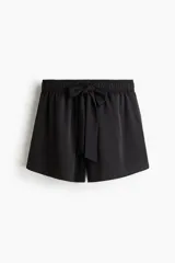 Short negro de sarga con cintura elastizada y cordón para ajustar. De corte holgado y tiro alto, con bolsillos laterales.