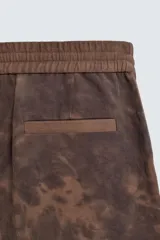 Bermuda estilo jogger de calce relajado, color marrón con efecto tie-dye. Posee cintura elástica ajustable con cordón y bolsillos delanteros y traseros de vivo.