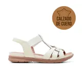 Sandalia de cuero Usaflex modelo Catri, color marfil con suela baja en tono marrón. Presenta diseño de tiras cruzadas en la parte delantera y tira elástica en el empeine.