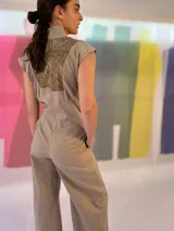 Mono largo azul marino con estampado dorado en la parte superior, cuello mao, sin mangas, con cinturón y bolsillos laterales.