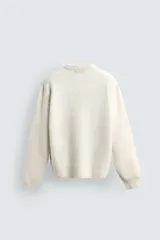Jersey de punto con textura efecto pelo, corte boxy fit, cuello redondo y manga larga con acabados en rib.