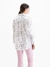 Camisa de poplin blanca con rayas verticales y estampado de corazones formados por cadenas, corte holgado, cuello clásico, mangas largas y bolsillo aplicado en el frente.