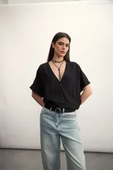 Blusa blanca con diseño cruzado, escote en V y mangas cortas.