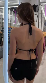 Top negro con escote halter profundo, apliques de brillos plateados y abertura frontal.