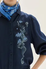 Camisa de lyocell azul oscuro con bordado floral a tono en el pecho y mangas voluminosas. Presenta un calce recto.