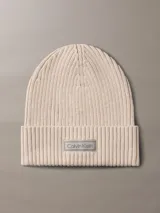 Gorro tipo beanie de punto acanalado en color beige, con vuelta y parche frontal con el logo de Calvin Klein.