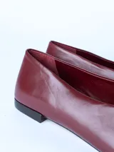 Zapato tipo ballerina de cuero color bordó, con punta cuadrada y suela plana.