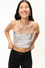 Crop top ajustado de napa fina color plateado, con breteles ajustables y diseño de tiras cruzadas en el escote. Presenta pinzas en la parte delantera y zona elástica en la espalda.