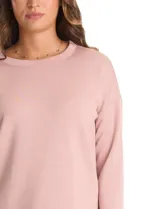 Buzo de punto de alta densidad con tacto aterciopelado, color rosa. Presenta escote a la base, mangas tres cuartos y hombros caídos. Su diseño es minimalista, con calce recto y holgado, y cuenta con pequeños tajos laterales en el ruedo.