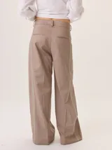 Pantalón de pierna ancha color beige, con pespuntes a contratono y una tira vertical contrastante en el lateral que estiliza la figura.