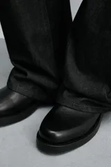 Bota de caña alta confeccionada en piel con acabado granulado y suela de goma con volumen a tono.