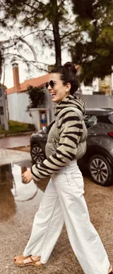 Campera puffer cropped color verde militar con mangas y capucha de polar estampado con cebra en blanco y negro.