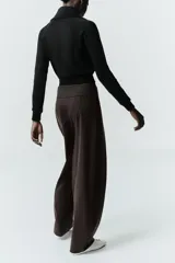 Chaqueta de felpa negra con cuello solapa, manga larga con puño, bolsillos de plastrón en el delantero y cierre frontal con cremallera.