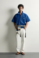 Jeans de corte recto color celeste claro, con tiro medio, diseño de cinco bolsillos, efecto lavado y bajo con acabado irregular deshilachado.