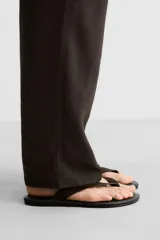 Sandalia marrón de piel con acabado serraje en el empeine, plantilla de piel y suela plana a tono.