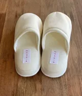 Pantuflas de dama color blanco, con diseño de punta cerrada y plataforma. Presentan una etiqueta con la marca Zephia en la plantilla.