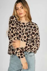 Sweater de punto con textura suave y diseño de estampado animal print de leopardo. Presenta cuello redondo, mangas largas y puños acanalados en color liso.