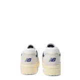 Championes urbanos New Balance modelo 550, con diseño de corte bajo inspirado en el básquet. Presentan una combinación de cuero y malla en tonos beige y azul marino, con suela de goma en tono crema envejecido.