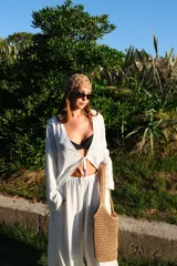 Pantalón de corte amplio y tiro medio, confeccionado en tela crepe color beige, con diseño fluido y holgado.