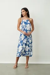 Vestido midi de corte holgado con estampado floral en tonos azul y blanco, presenta escote halter con breteles finos y diseño sin mangas.