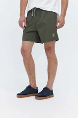 Short de baño bordó liso, de corte largo, con cintura elástica ajustable mediante cordón, bolsillos laterales y un pequeño logo estampado en el lateral.