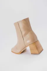 Botas plateadas de cuero con caña media, cierre lateral con cremallera, punta cuadrada y tacón geométrico de madera.