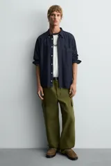 Mocasín color marrón de piel serraje, con antifaz y hebilla metálica.