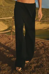 Pantalón de tejido de punto color negro, con cintura elástica acanalada y cordones de ajuste. Presenta un corte holgado y recto.