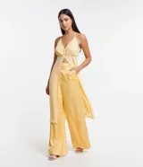 Pantalón pantalona amarillo satinado de corte amplio, con trabillas en la cintura, cierre de botón y cremallera, y pliegues.