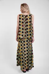 Musculosa de cuello redondo, confeccionada en tejido transparente con diseño de cuadrados de terciopelo a tres colores, con cierre de botones en la espalda.